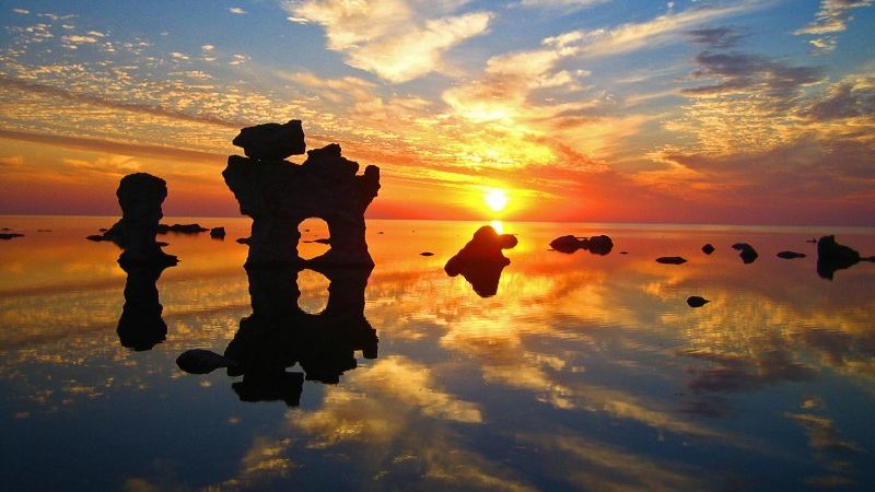 Solnedgång över raukar och hav på Gotland - bussresor Sverige.